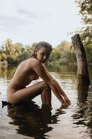 Portrait Of Nude Tanned Woman Sitting On The Bank Of The River by Stocksy  Contributor Anastasia Mihaylova (Shpara) - Stocksy