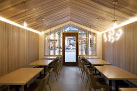 Simple small three door diner with sofa and tv. Urban Cabin Small Space Conscious Restaurant With Cozy Modern Ambiance
