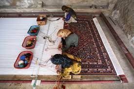 afghan woman weaves not carpet but her