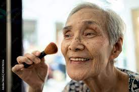 happy asian senior woman enjoy makeup