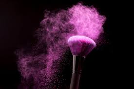 makeup brush with purple powder dust on