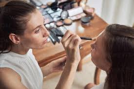 crop focused makeup artist applying