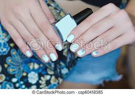 Female Hands With Light Blue Nail Design Holding Nail Polish Bottle