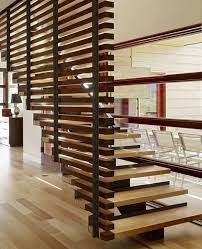 This stunning example of modern architecture features a curved design made with real wood stained a medium brown, metal balusters and a wood hand rail. Room Dividers Partitions Stairs Design Modern Contemporary Stairs Staircase Railing Design