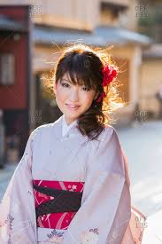 Traditionally, kimonos were worn layer upon layer. Portrait Of A Smiling Young Japanese Woman Wearing A Traditional Kimono Stock Photo Offset