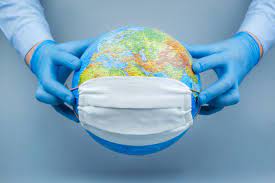 Premium Photo | Hands in medical gloves put a protective mask on the globe.  world coronavirus / corona virus attack concept.concept of fight against  virus.