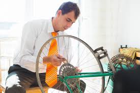 can you add gears to a fixed gear bike - A man repairing a bike rear wheel