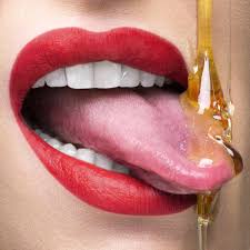 tongue catching dripping honey stock photo