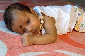 cute indian baby boy lying on front one