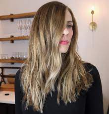 Brown wavy hairstyle with side part 50 Best Haircuts For Long Faces In 2021 Hair Adviser