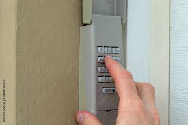 hand entering code on keypad garage