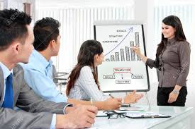 Young Business Woman Presenting Chart On White Board During Meeting