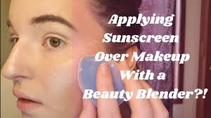 applying sunscreen over makeup with a