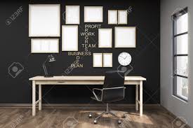 Multiple Posters In Frames On Black Wall Of Home Office Wooden