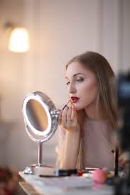 free photo young woman putting on makeup