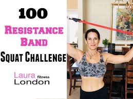 Wrap the resistance band around your legs above the knee. 100 Resistance Band Squat Challenge With Laura London