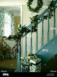 Le feuillage frais garland sur les rampes d'escalier bleu sur la petite  salle décorée pour Noël avec les cadeaux emballés sur le plancher Photo  Stock - Alamy