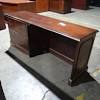 This office desk has a large, polished top with drawers for storage. 1