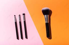 orted makeup brushes atop a pink and