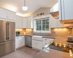 renovated kitchen with stainless steel appliances, granite countertops, and white cabinets