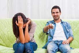 若いカップルは、自宅のソファに座っています。女性は、彼女の男がテレビで見ている彼女は好きではないので欲求不満です。 の写真素材・画像素材. Image  63826443.