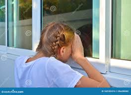 A Girl Peeps through the Window. Voyeurism. Children`s Curiosity. Stock  Photo 