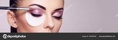 makeup artist applies eye shadow stock