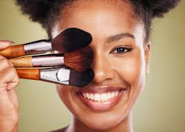 black woman makeup brush and smile in