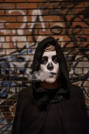 grim reaper exhaling smoke by stocksy