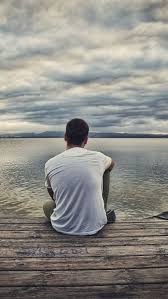 sad alone boy sitting on the bank of