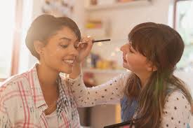 young women friends applying makeup