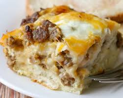 A square of sausage and egg casserole with a crescent roll base, topped with cheddar and green onions, served on a white. Biscuit Egg Casserole Quick Easy Video Lil Luna
