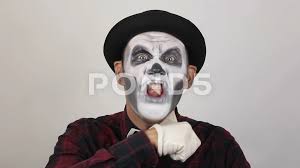 a horrible man in clown makeup makes