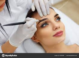 beautician doing eyebrow makeup tattoo