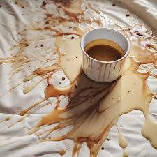 cup of coffee spilled on white carpet