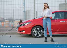 Electric Car Charging in Street. Ecological Car Connected and Charging  Batteries. Girl Use Coffee Drink while Using Stock Image - Image of energy,  ecological: 176828111