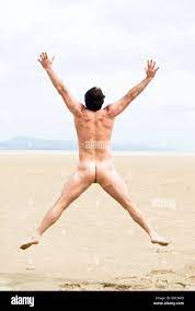 A naked fit forties man is jumping for joy on a beautiful sandy beach on  the island of Fuerteventura Stock Photo - Alamy