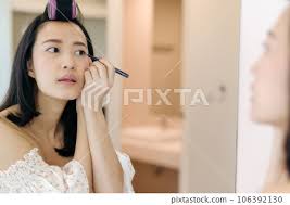 young asian woman applying makeup