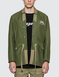 The blended cotton canvas jacket shell features two deep bellow style hip pockets, button closures, and a concealed drawstring waist. Shop Maharishi Upcycled M59 Skull Field Kimono In Green