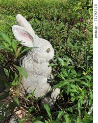 Rabbit Garden Ornament On The Flowerbed