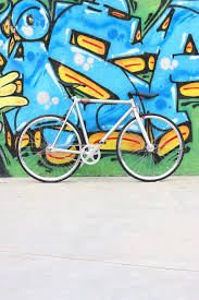 white city bike parked beside wall with