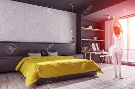 This bedroom is full of vibrant purples and pinks. Woman In Corner Of Modern Bedroom With Concrete And Gray Walls Stock Photo Picture And Royalty Free Image Image 118647713
