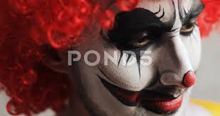 scary clown viciously looks askance at