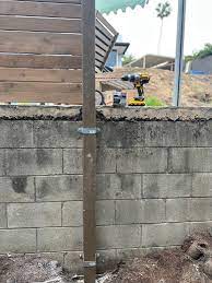 fence post attach to retaining wall