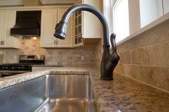 bronze faucet on a stainless sink