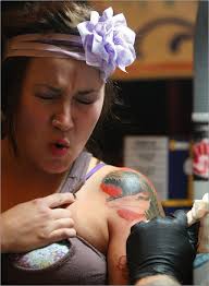 Laura Rost of Sharon, Conn. reacted while having a T-Rex tattooed on. Globe Staff Photo / Essdras M. Suarez - 1__1283607015_1717