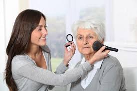 helping old woman to put makeup on