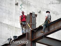 construction workers straddling a beam