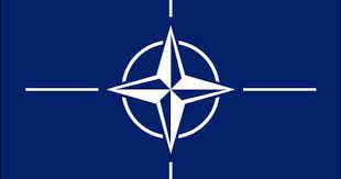 The flag of the north atlantic treaty organization (nato) consists of a dark blue field charged with a white compass rose emblem, with four white lines radiating from the four cardinal directions. Nato Flag The North Atlantic Treaty Organization Nato Flag Flags Of The World Flag