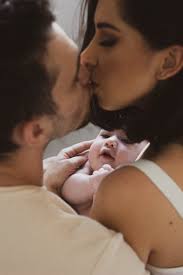 couple kissing with baby free stock photo